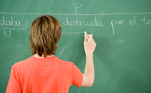 Elementary student writing on chalkboard