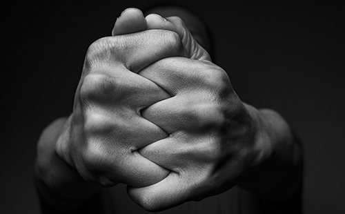 Black and white photo of two hands clasped together