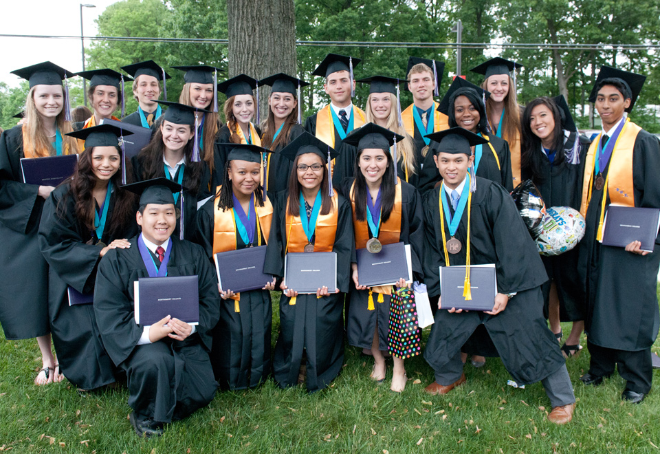 MC graduates posing outdoors with diplomas