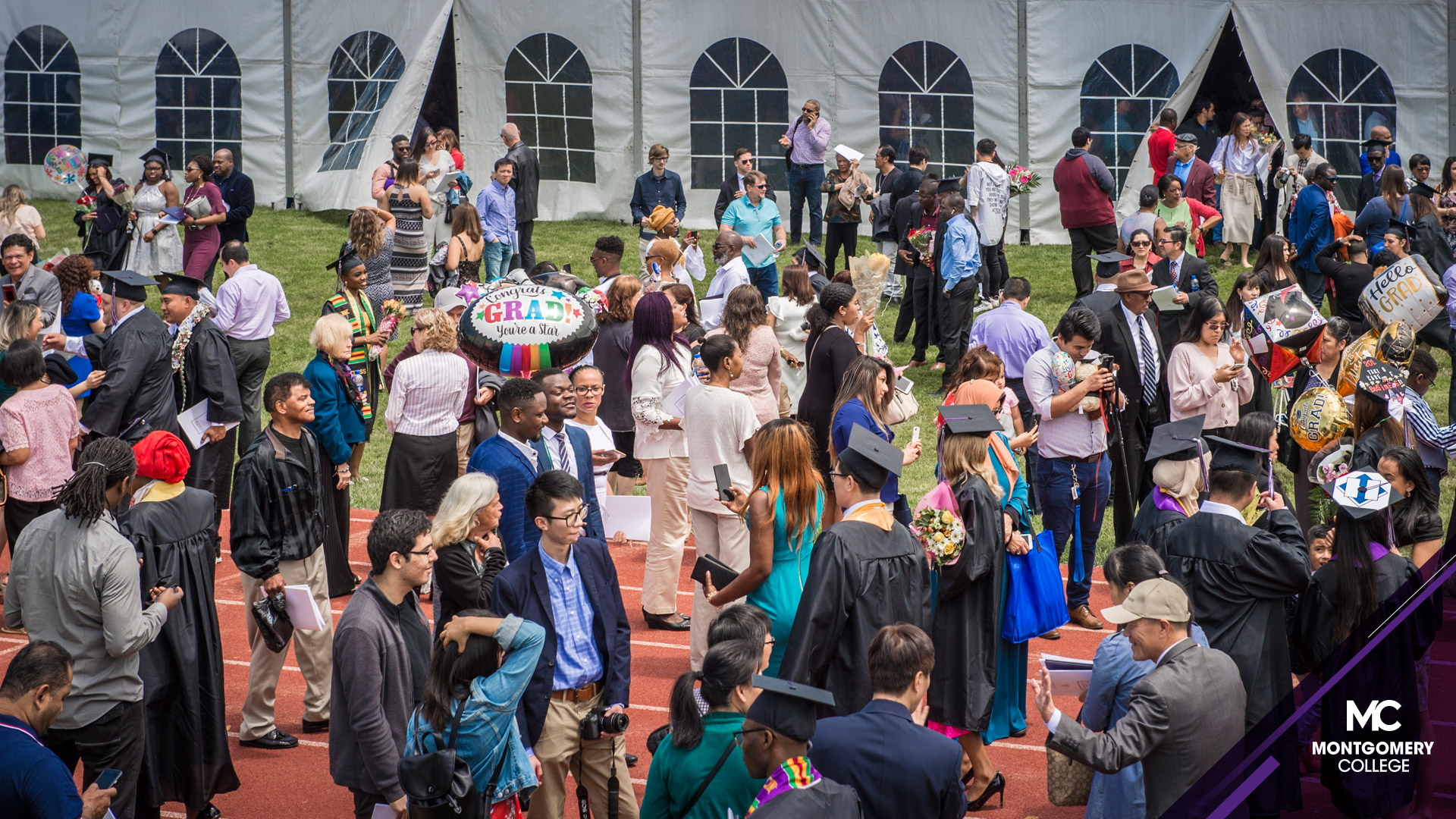 毕业典礼后，人群在帐篷外交缠。