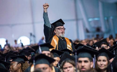 student celebrating graduation with fist in air