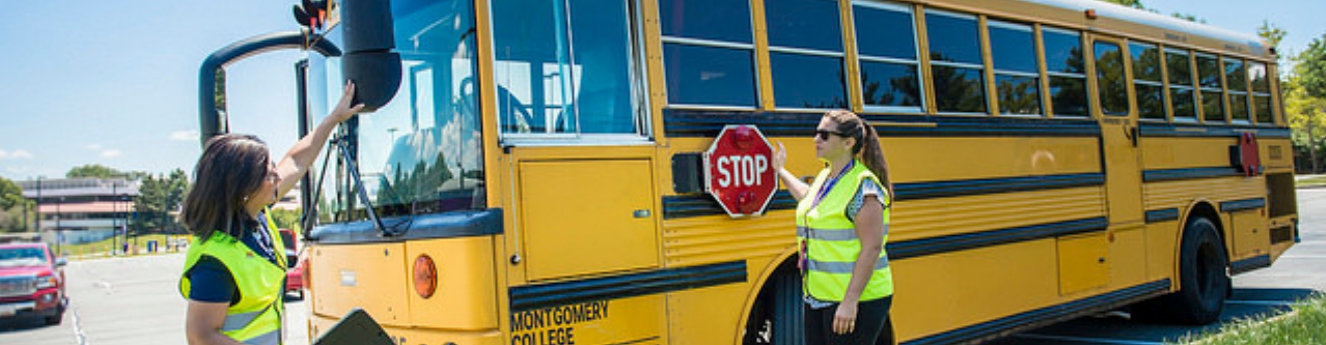 An instructor helping a student study the exterior of a bus
